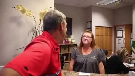A patient chatting with a team member at the Chenet Dental front desk.