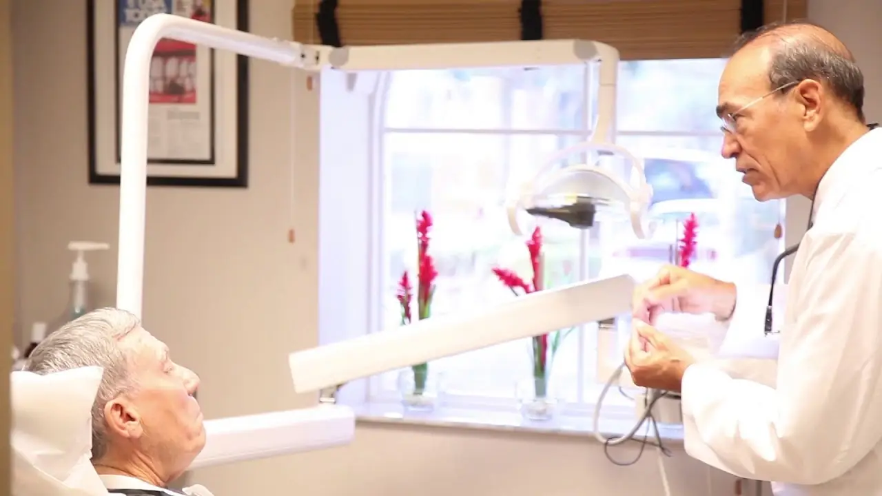 Dr. Cedric Chenet talking with a patient in one of his treatment rooms.