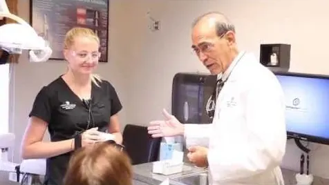 Dr. Chenet and a dental hygienist with a patient in the treatment room.